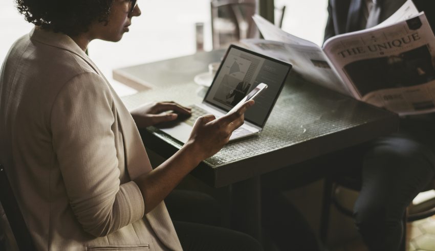 wiarygodność marki kobieta trzyma telefon siedzi przed laptopem